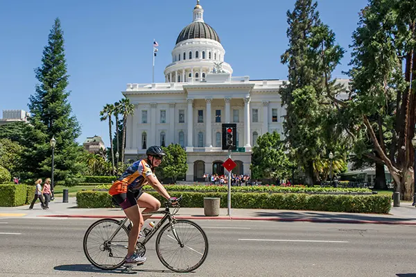 Woman riding a bicycle in front of a courthouse
