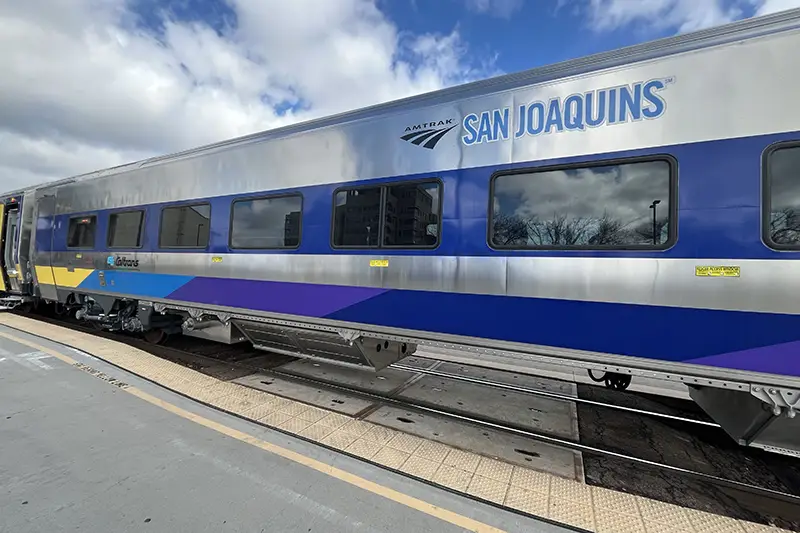 Blue and Silver Amtrak passenger train stopped at a platform
