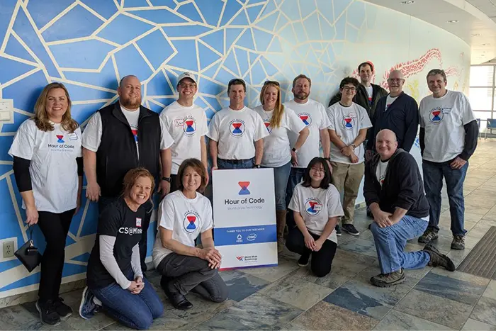 Employees in t-shirts that say hour of code