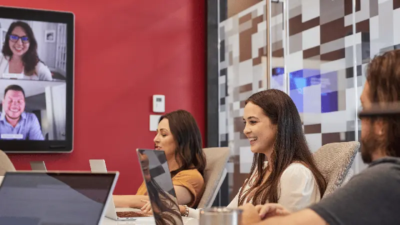 Women with laptops in a video meeting room