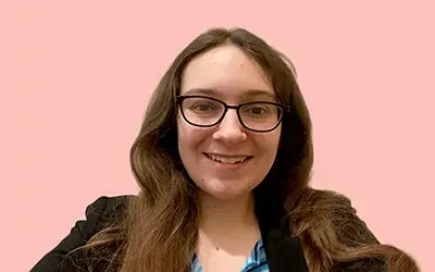 woman in suit jacket and glasses smiling